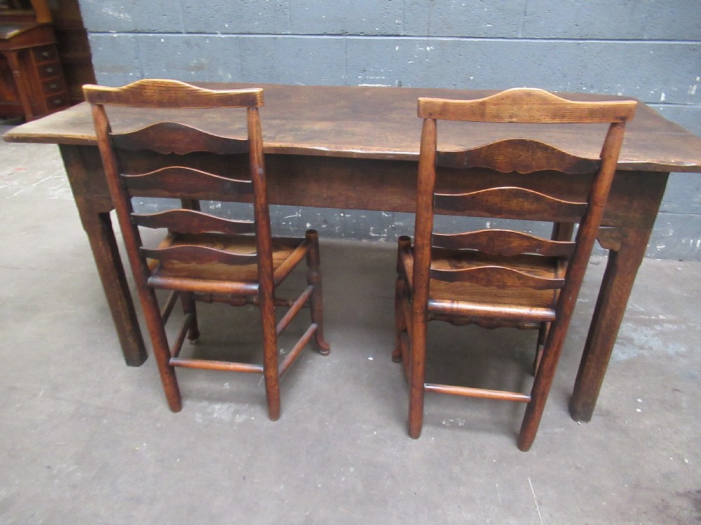 An early 19th-century wooden dining table featuring a rectangular planked top and four sturdy tapering legs. View VIII