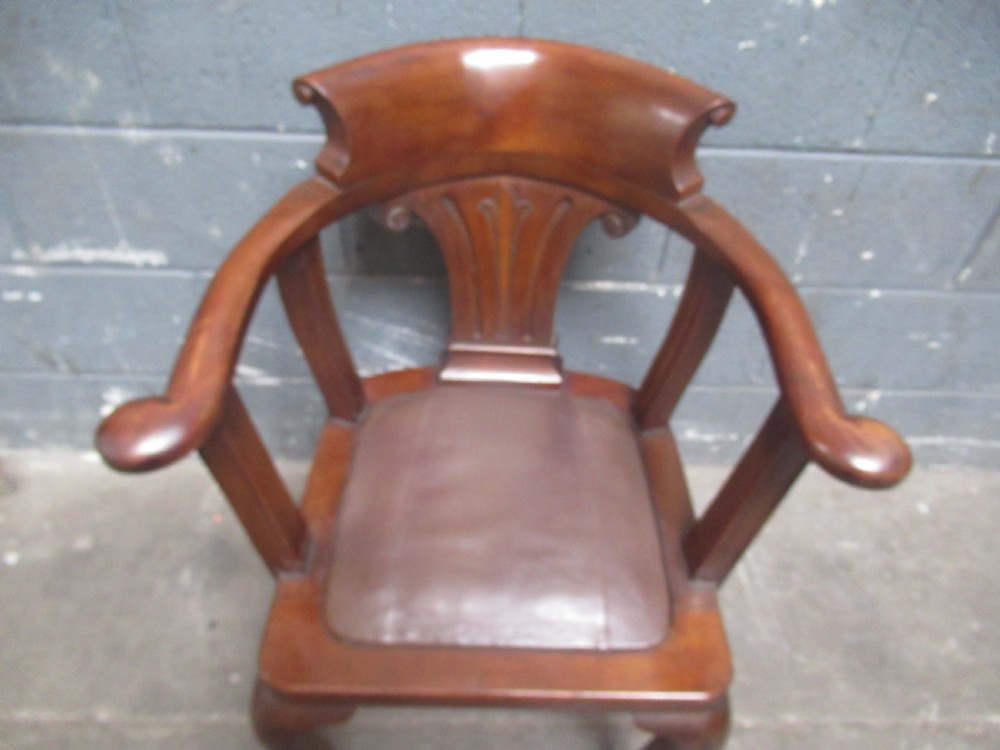 A 1920s mahogany desk armchair featuring a curved backrest, carved central splat, leather seat pad, and cabriole legs with ball-and-claw feet. View X