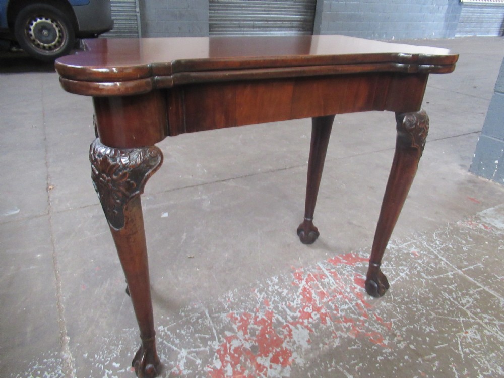 A Georgian mahogany fold-over card table featuring carved cabriole legs with acanthus knees and claw and ball feet. View II
