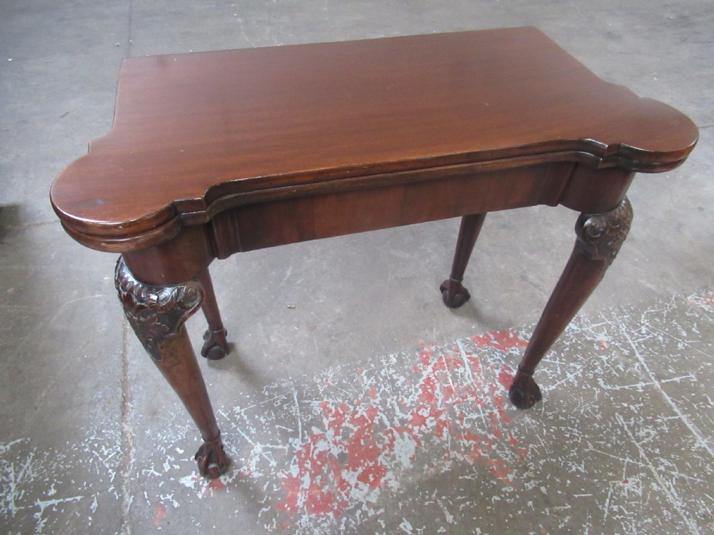 A Georgian mahogany fold-over card table featuring carved cabriole legs with acanthus knees and claw and ball feet. View III