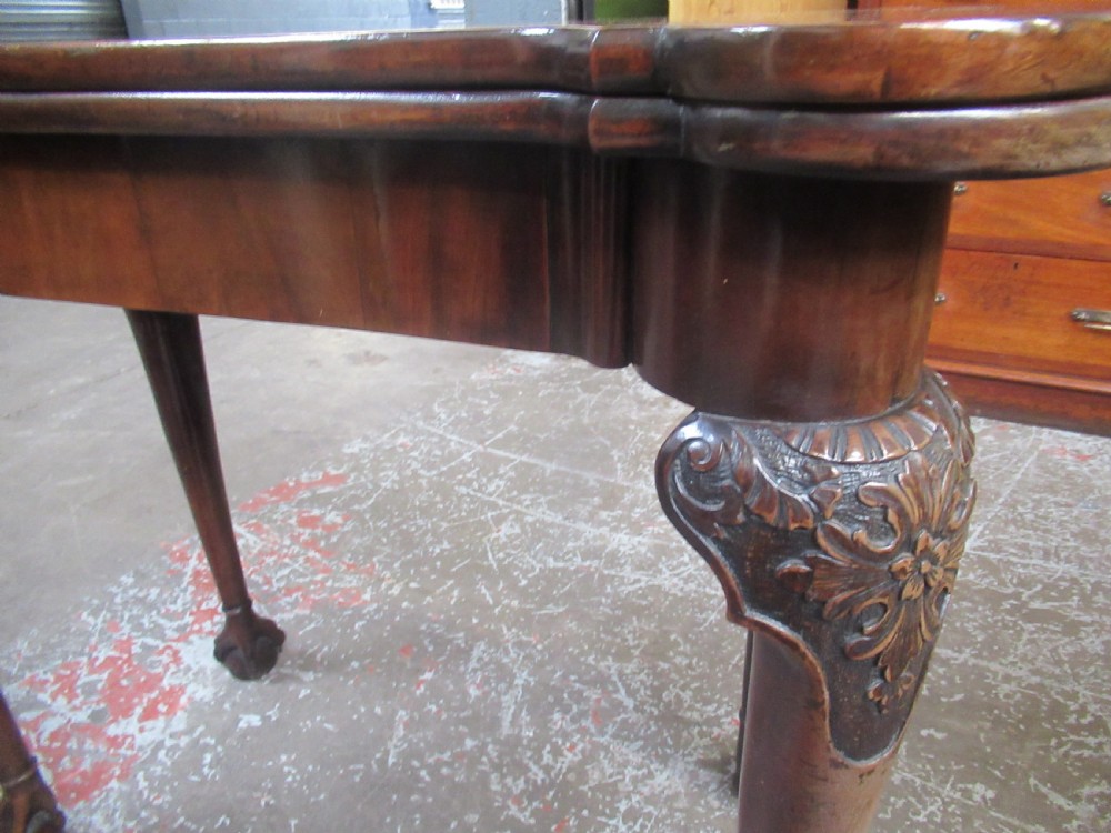 A Georgian mahogany fold-over card table featuring carved cabriole legs with acanthus knees and claw and ball feet. View XV