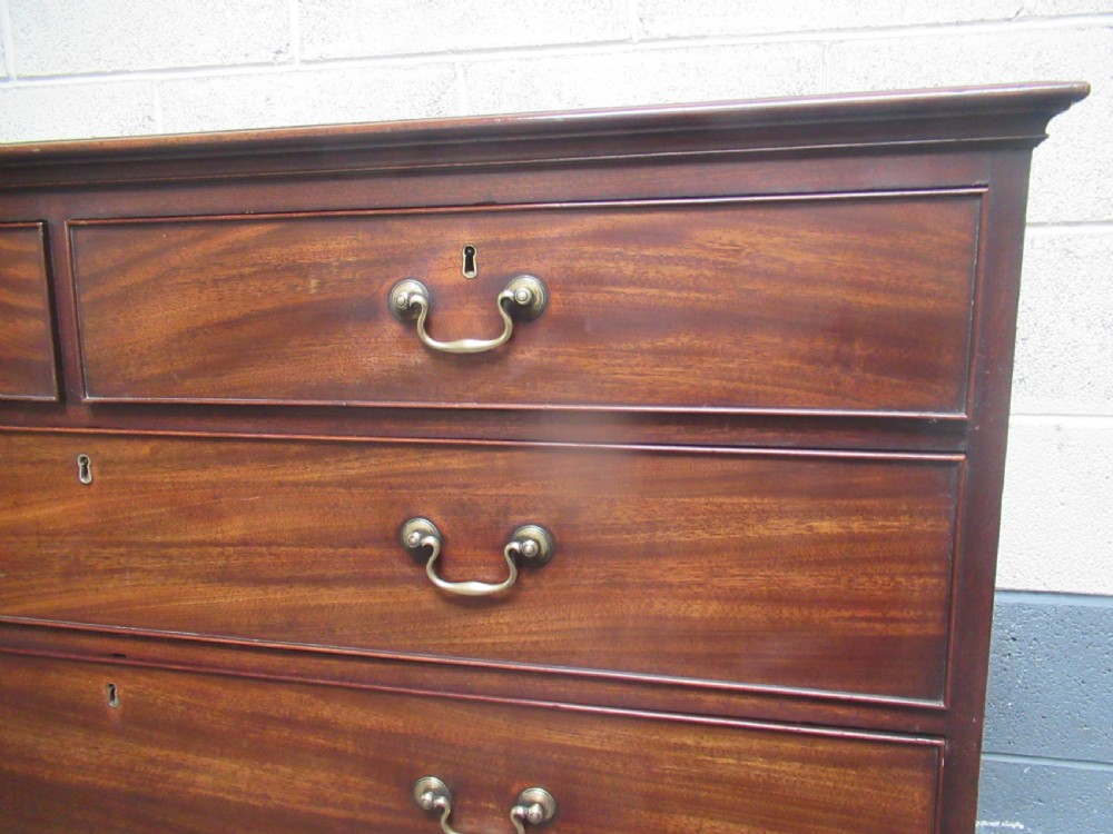 A late Georgian tall mahogany chest of drawers with brass swan-neck handles set on bracket feet. View VI