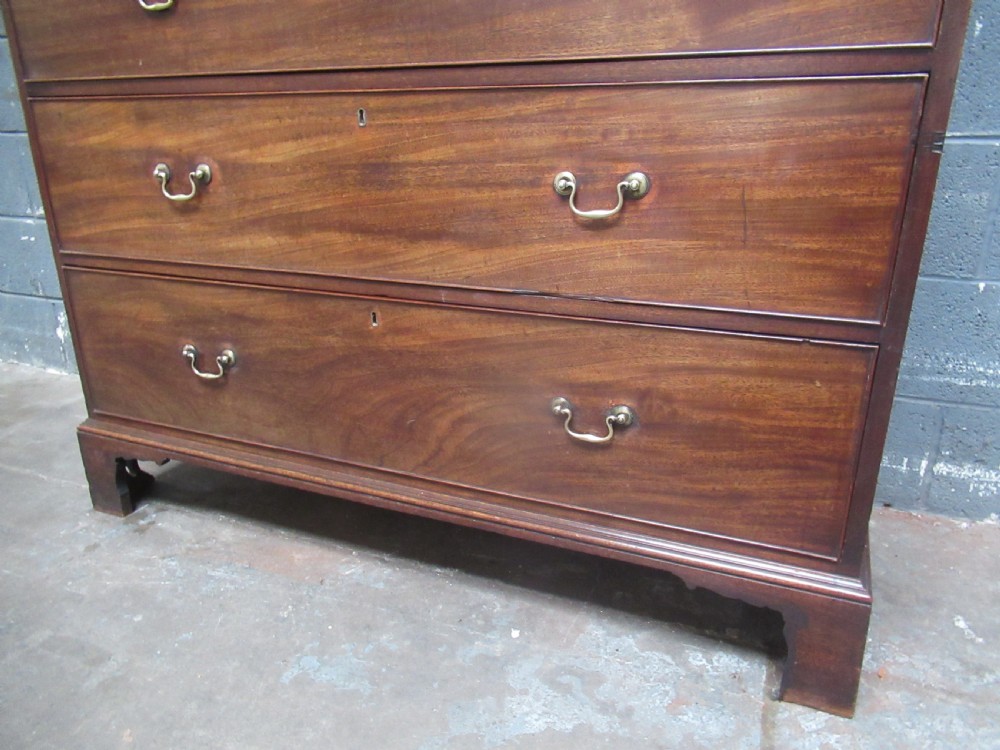 A late Georgian tall mahogany chest of drawers with brass swan-neck handles set on bracket feet. View VII