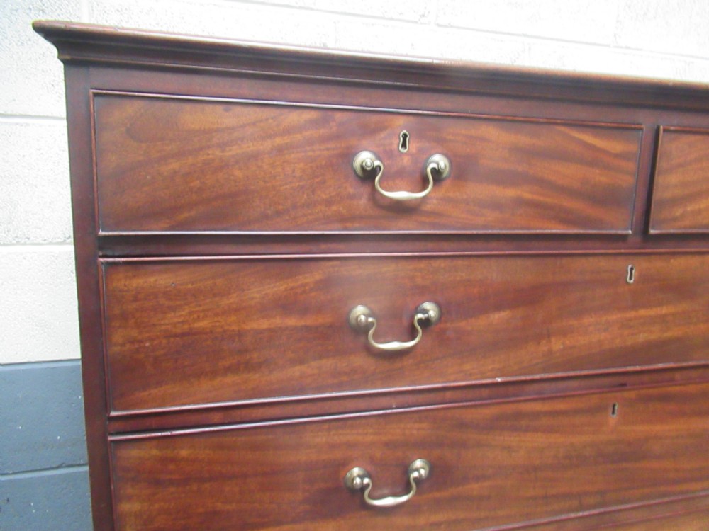 A late Georgian tall mahogany chest of drawers with brass swan-neck handles set on bracket feet. View VIII