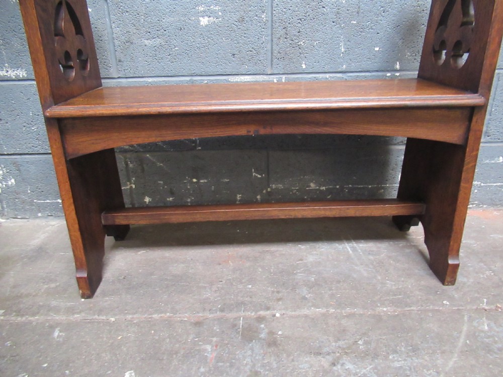A solid oak Arts and Crafts bench seat with raised side uprights featuring pierced trefoil cutouts. View XI