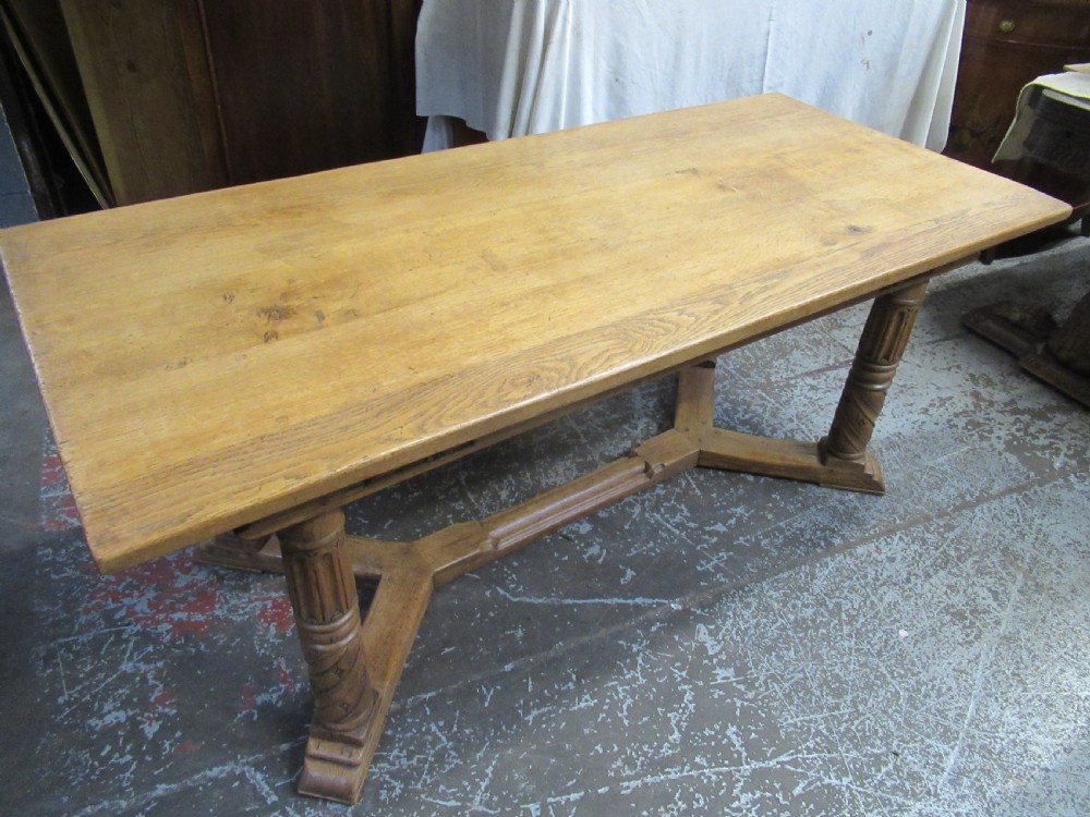 A rectangular light oak refectory dining table featuring carved aprons, spiral turned legs, and a low H-shaped stretcher base. View II