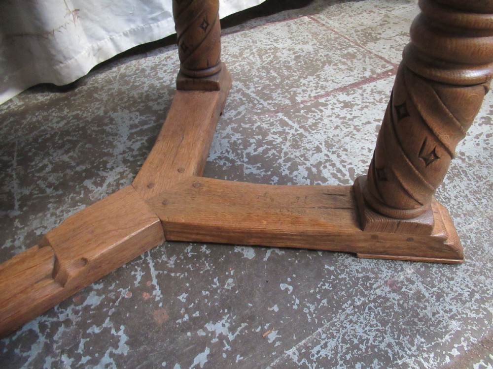 A rectangular light oak refectory dining table featuring carved aprons, spiral turned legs, and a low H-shaped stretcher base. View XIII