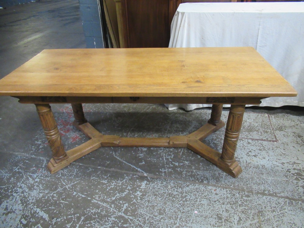 A rectangular light oak refectory dining table featuring carved aprons, spiral turned legs, and a low H-shaped stretcher base. View XIV