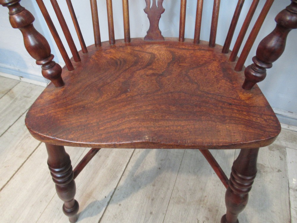 A 19th-century yew wood Windsor armchair featuring a hoop back, central pierced splat, turned arm supports, shaped seat, and crinoline stretcher. View III
