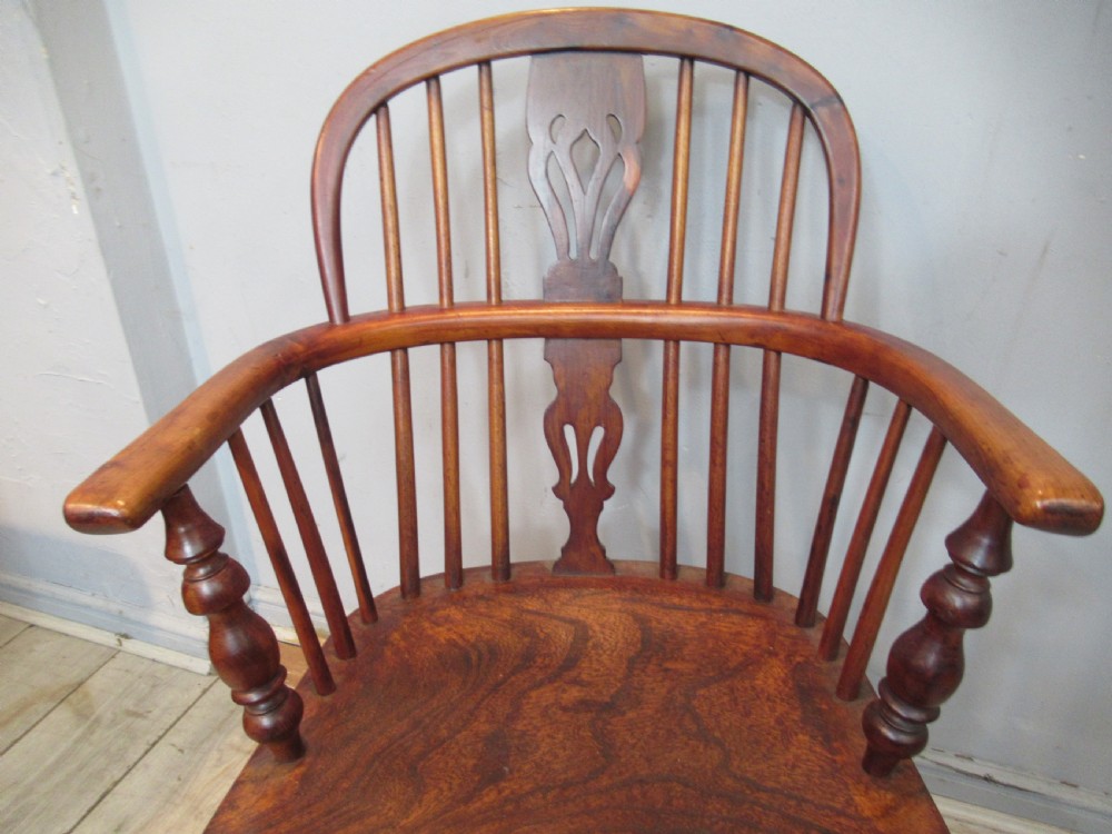 A 19th-century yew wood Windsor armchair featuring a hoop back, central pierced splat, turned arm supports, shaped seat, and crinoline stretcher. View IV