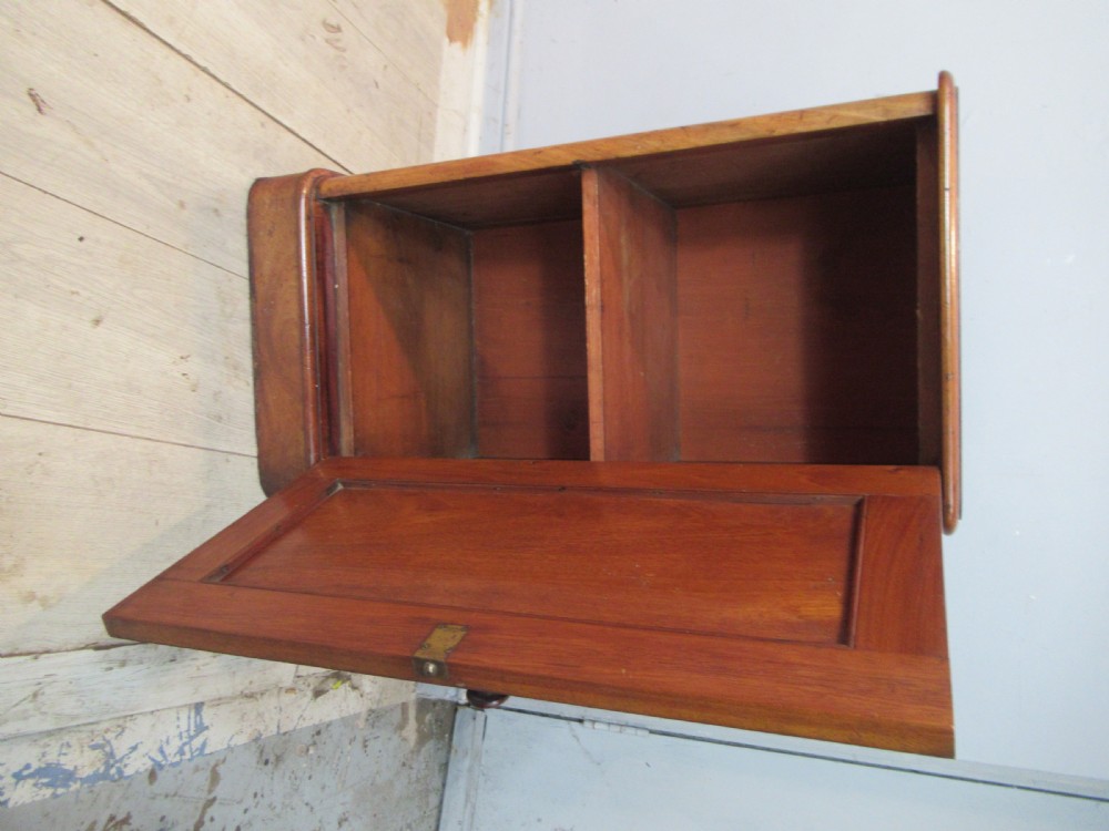 A Victorian mahogany bedside cabinet featuring an arched recessed panel door, a turned wooden knob, and a solid plinth base. View III