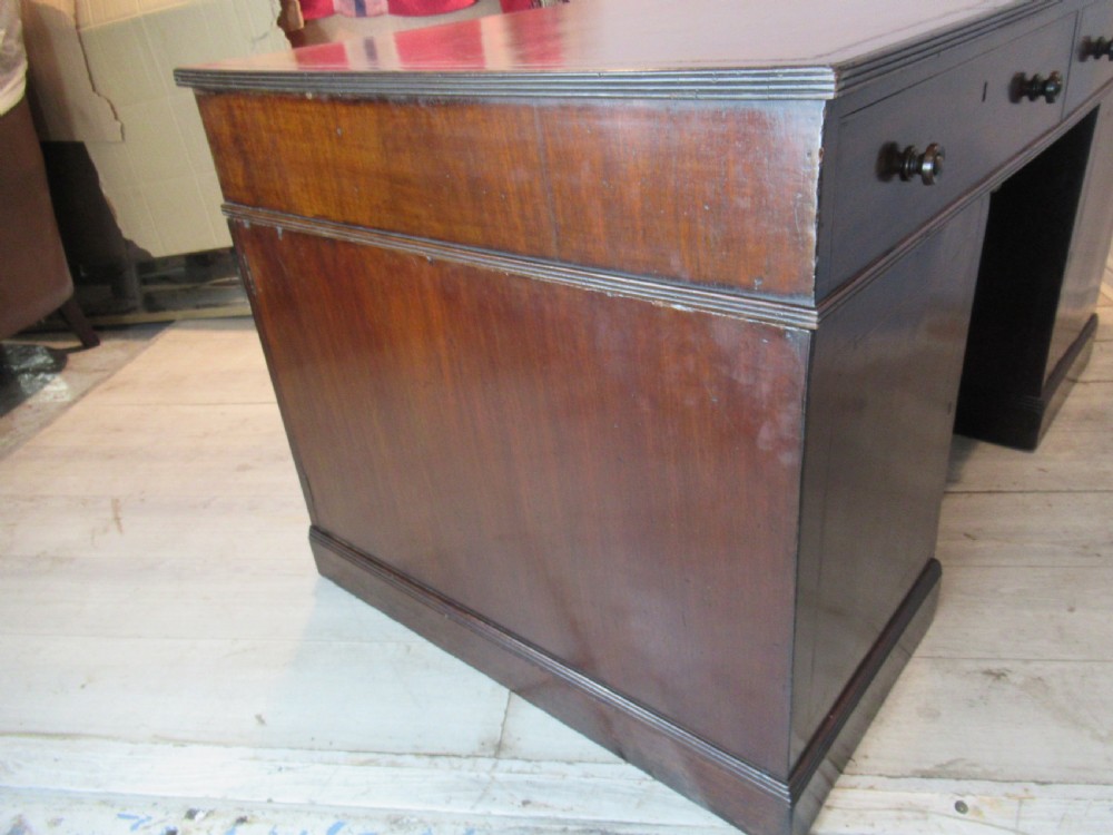 A 19th-century mahogany kneehole desk featuring a leather inset writing surface, two frieze drawers with turned wooden knobs, and two side pedestal cupboards. View XIV