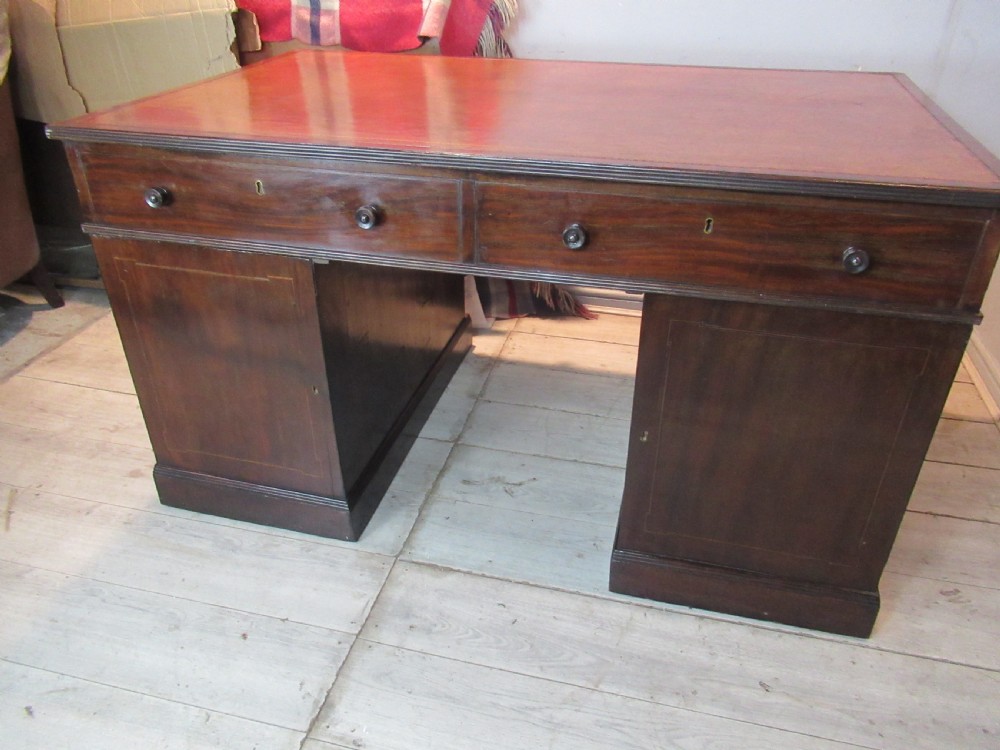 A 19th-century mahogany kneehole desk featuring a leather inset writing surface, two frieze drawers with turned wooden knobs, and two side pedestal cupboards. View XVI