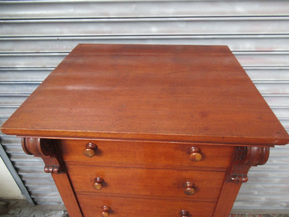 A tall Victorian mahogany Wellington chest featuring seven graduated drawers with turned wooden knobs and carved upper corbels. View IV