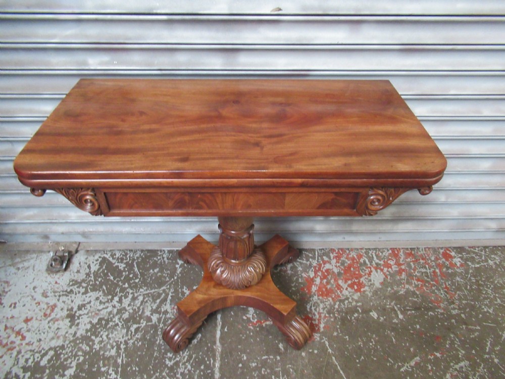 Victorian mahogany fold-over tea table featuring a rectangular swivel top, carved scroll frieze details, a central turned column, and a quadruped base with scroll feet. View III