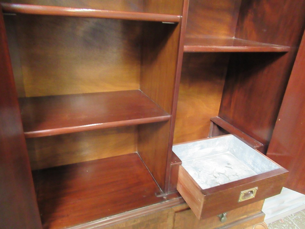 A 1930s mahogany cocktail cabinet on a stand featuring two upper doors with ornate brass strap hinges, lower drawers, cabriole legs, and claw and ball feet. View XI