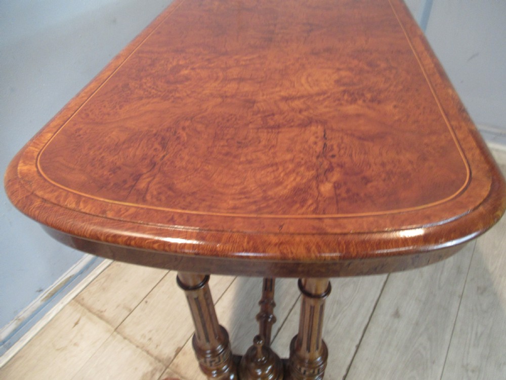 A Victorian burr oak side table featuring a polished rectangular top with rounded corners, supported by twin turned columns and a central finial stretcher. View III