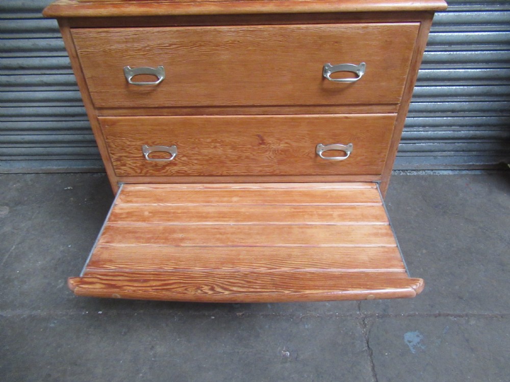 A pitch pine maritime chest of drawers featuring four drawers with flush metal handles and a raised gallery rim at the top. View VI