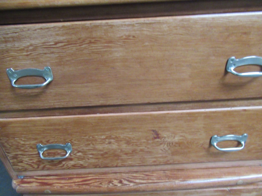 A pitch pine maritime chest of drawers featuring four drawers with flush metal handles and a raised gallery rim at the top. View X