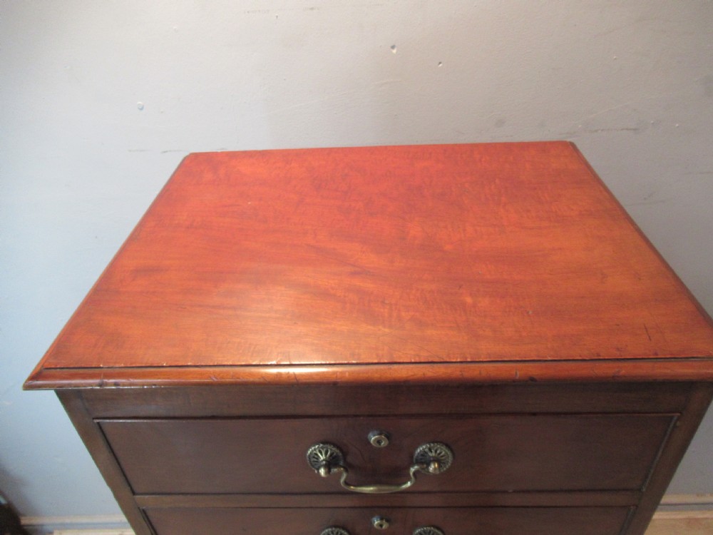 A tall, slim Victorian mahogany cabinet featuring three upper drawers with brass handles above a single lower cupboard door. View X