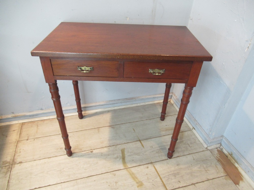 A late Victorian mahogany side table featuring two drawers with brass drop handles and four ring-turned bamboo-style legs. View II