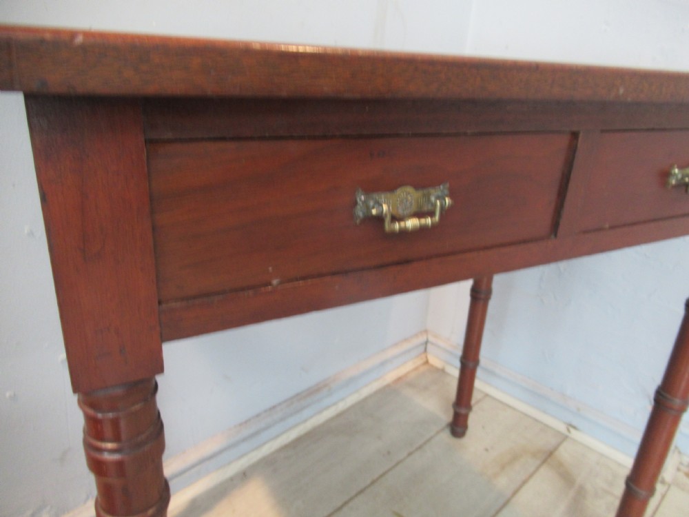 A late Victorian mahogany side table featuring two drawers with brass drop handles and four ring-turned bamboo-style legs. View V