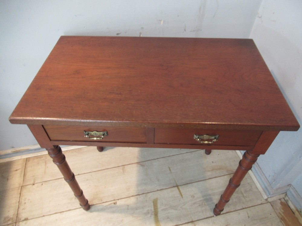 A late Victorian mahogany side table featuring two drawers with brass drop handles and four ring-turned bamboo-style legs. View VII