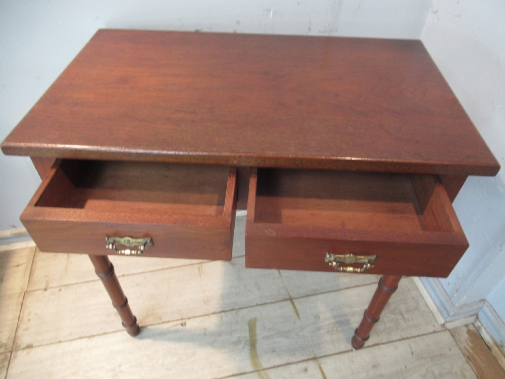 A late Victorian mahogany side table featuring two drawers with brass drop handles and four ring-turned bamboo-style legs. View X