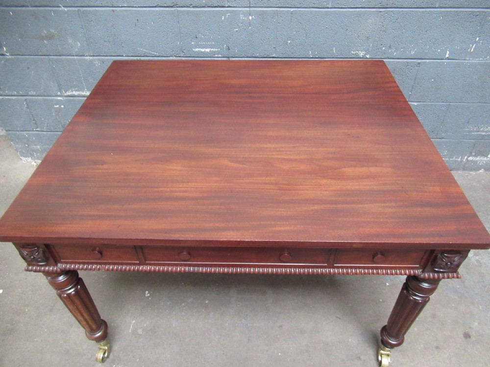 An early nineteenth century mahogany extending library desk with side pull-out trays, reeded turned legs, and brass castors. View VIII