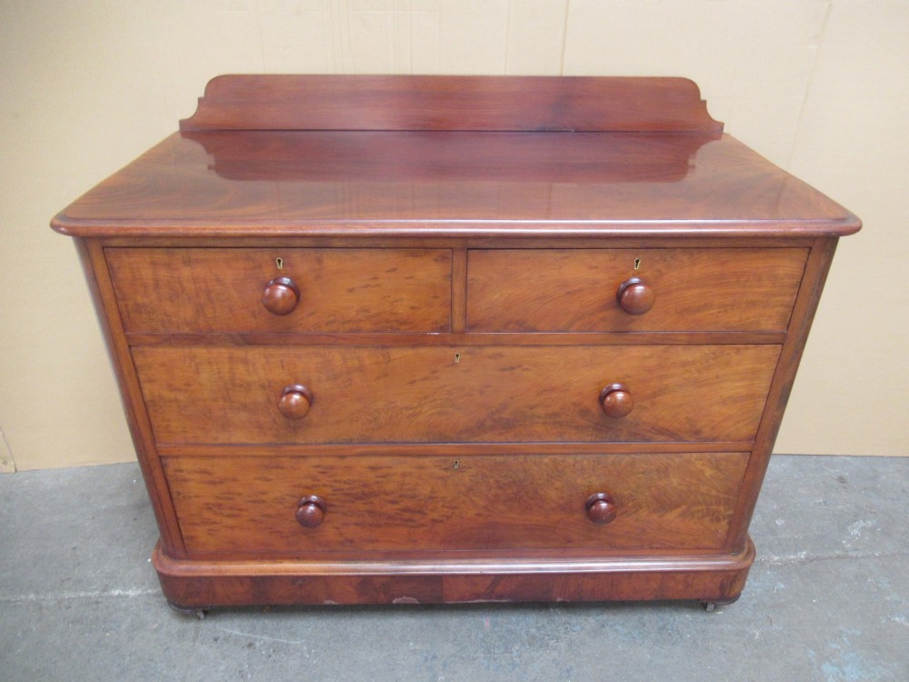 A Victorian mahogany chest of drawers featuring two short over two long drawers with turned handles and a low gallery upstand.