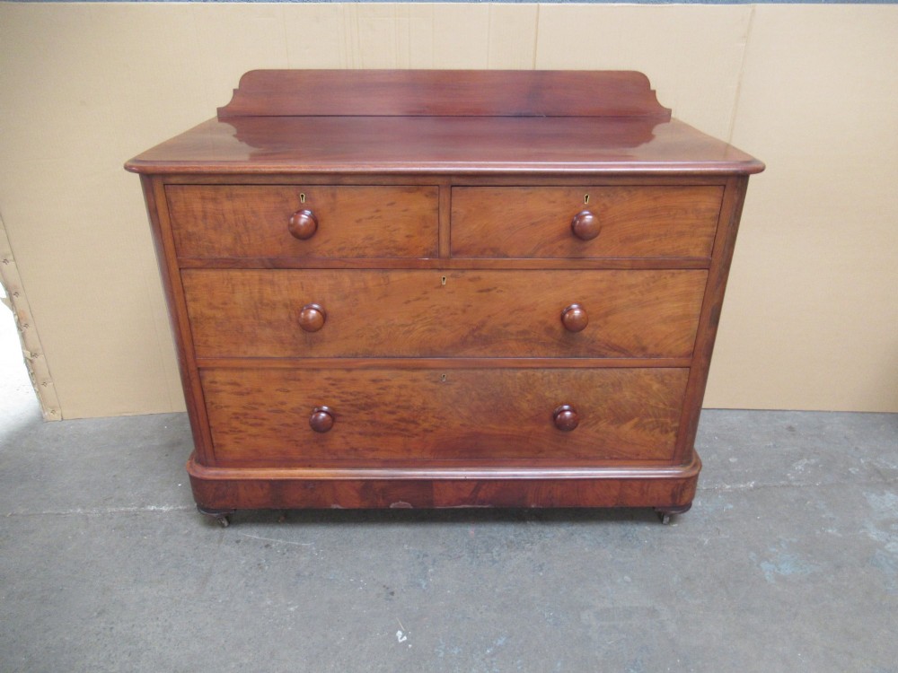 A Victorian mahogany chest of drawers featuring two short over two long drawers with turned handles and a low gallery upstand. View II