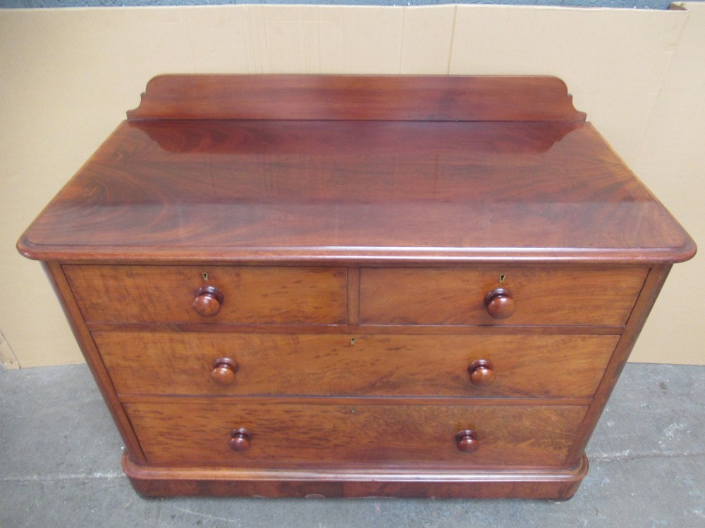 A Victorian mahogany chest of drawers featuring two short over two long drawers with turned handles and a low gallery upstand. View III