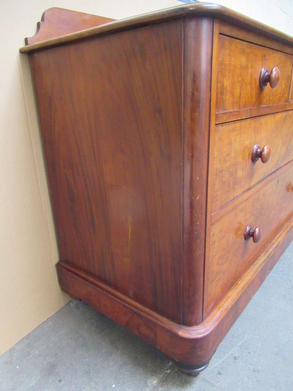 A Victorian mahogany chest of drawers featuring two short over two long drawers with turned handles and a low gallery upstand. View V