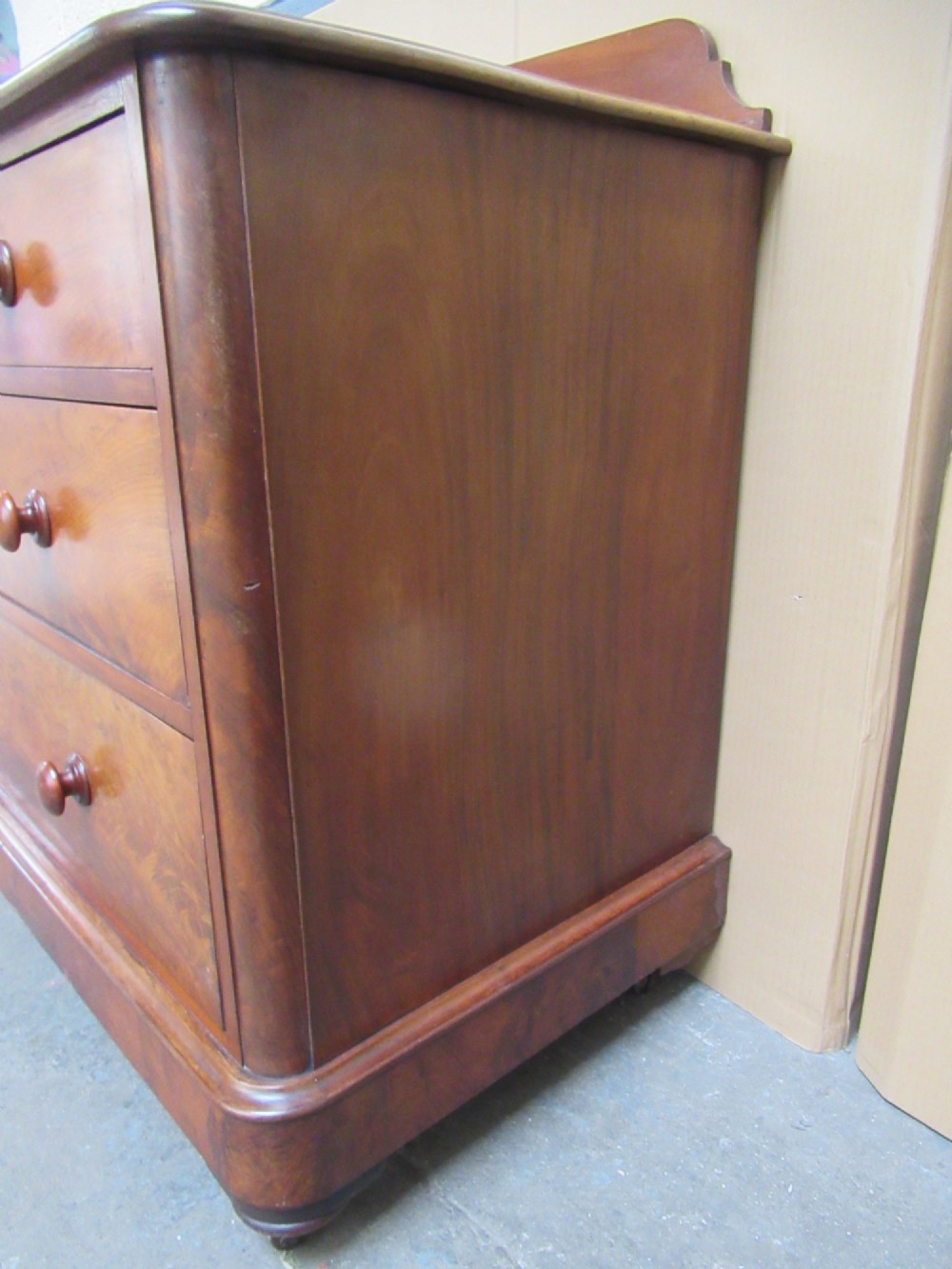 A Victorian mahogany chest of drawers featuring two short over two long drawers with turned handles and a low gallery upstand. View VI