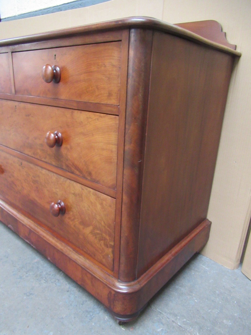 A Victorian mahogany chest of drawers featuring two short over two long drawers with turned handles and a low gallery upstand. View VII