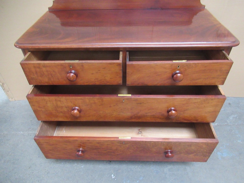 A Victorian mahogany chest of drawers featuring two short over two long drawers with turned handles and a low gallery upstand. View VIII