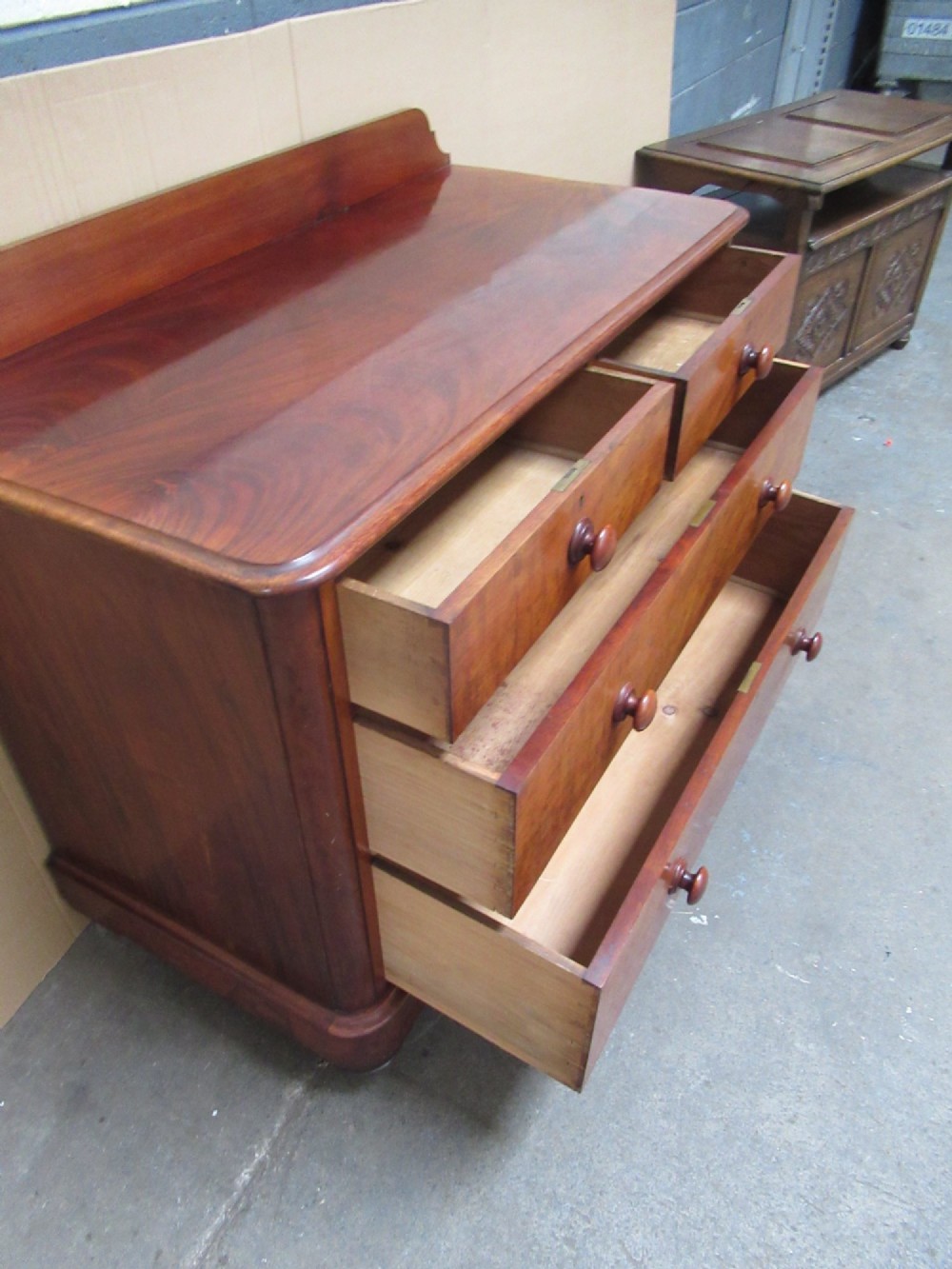 A Victorian mahogany chest of drawers featuring two short over two long drawers with turned handles and a low gallery upstand. View IX