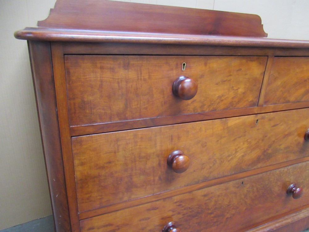 A Victorian mahogany chest of drawers featuring two short over two long drawers with turned handles and a low gallery upstand. View X