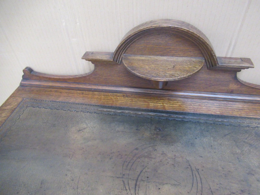 An Edwardian oak writing desk with a leather inset top, three drawers with brass handles, and a raised gallery back featuring a small bracket shelf. View IV