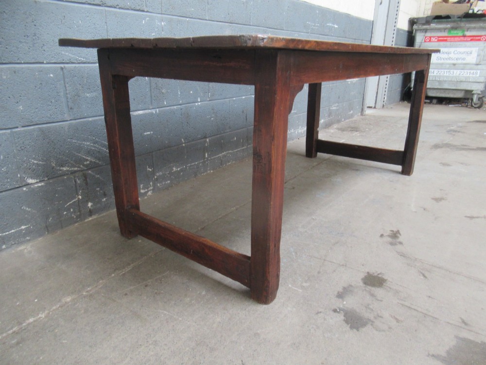 A 19th-century pine dining table with a wide plank top, straight legs, and side stretchers in a warm brown timber finish. View III