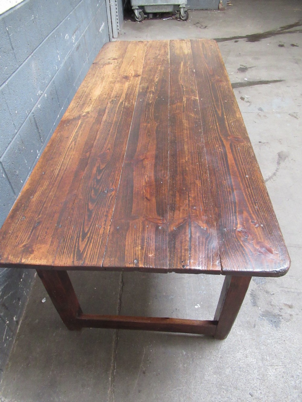 A 19th-century pine dining table with a wide plank top, straight legs, and side stretchers in a warm brown timber finish. View IV