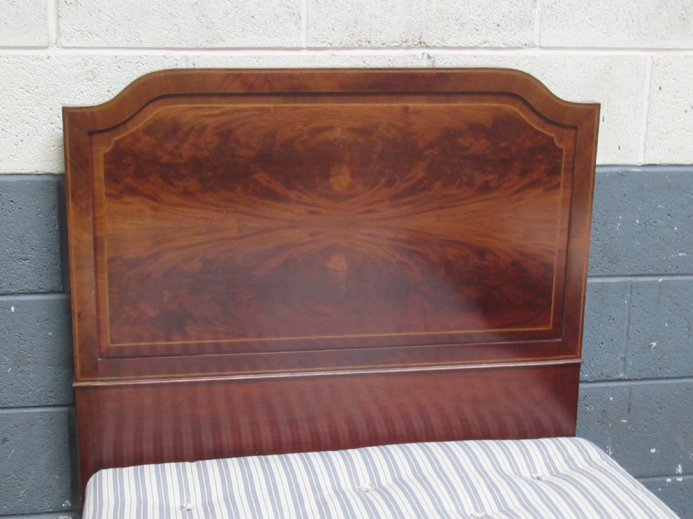A pair of Edwardian mahogany single beds featuring flame mahogany panels, fine boxwood inlay, and tapered square legs with brass castors. View IV