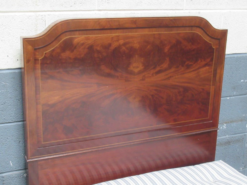 A pair of Edwardian mahogany single beds featuring flame mahogany panels, fine boxwood inlay, and tapered square legs with brass castors. View V