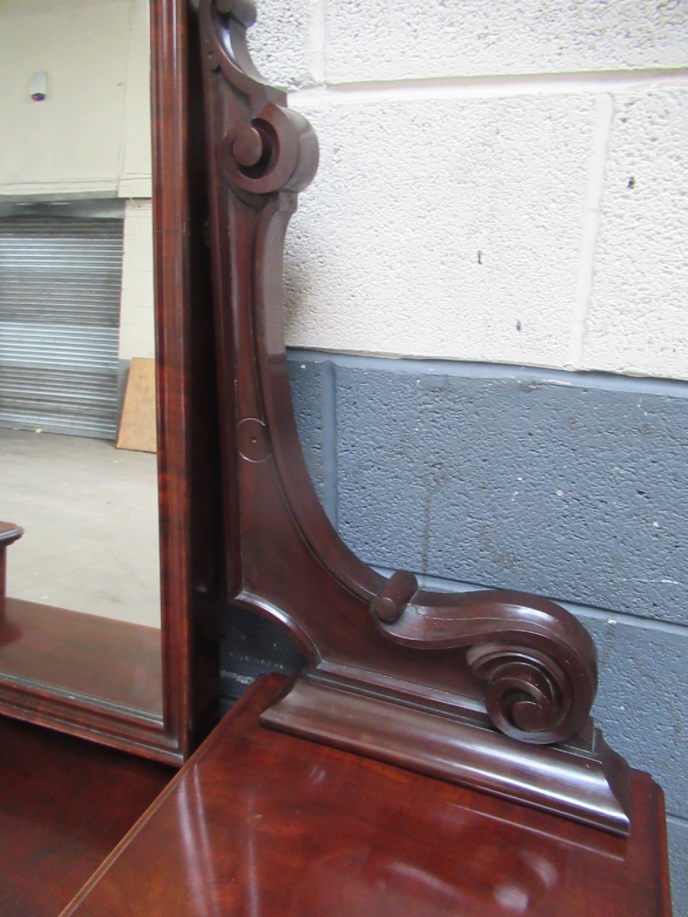 A Victorian mahogany dressing table featuring a central arched swing mirror with carved scroll supports, set above twin pedestals containing drawers with turned wooden handles. View IX