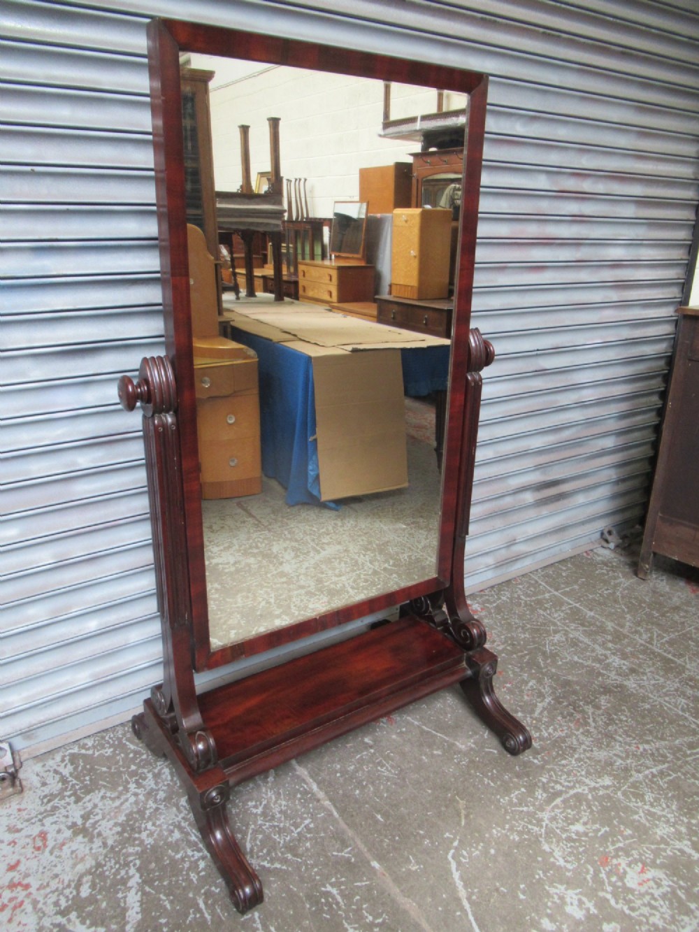 A 19th-century full-length mahogany cheval mirror featuring turned side adjustment handles, curved scroll legs, and a rectangular tilting glass frame. View II