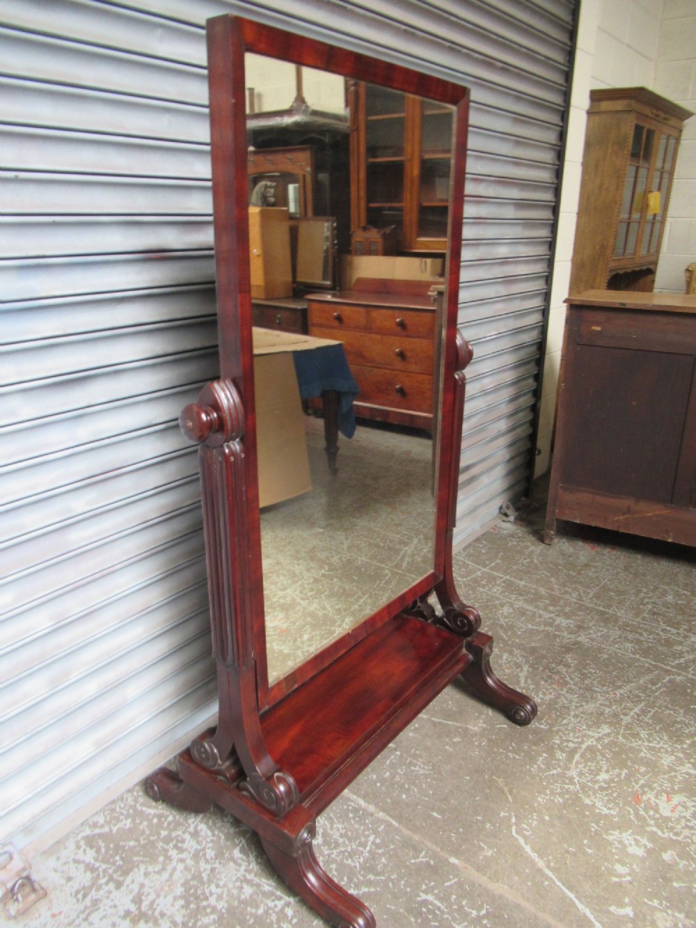 A 19th-century full-length mahogany cheval mirror featuring turned side adjustment handles, curved scroll legs, and a rectangular tilting glass frame. View III