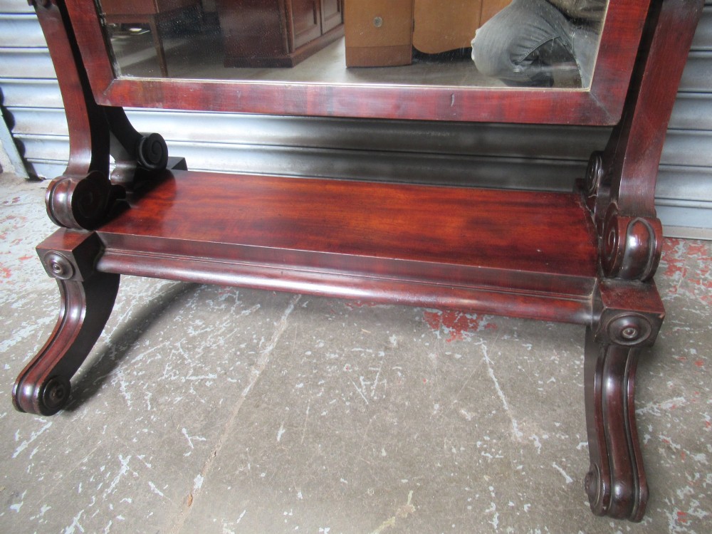 A 19th-century full-length mahogany cheval mirror featuring turned side adjustment handles, curved scroll legs, and a rectangular tilting glass frame. View IV