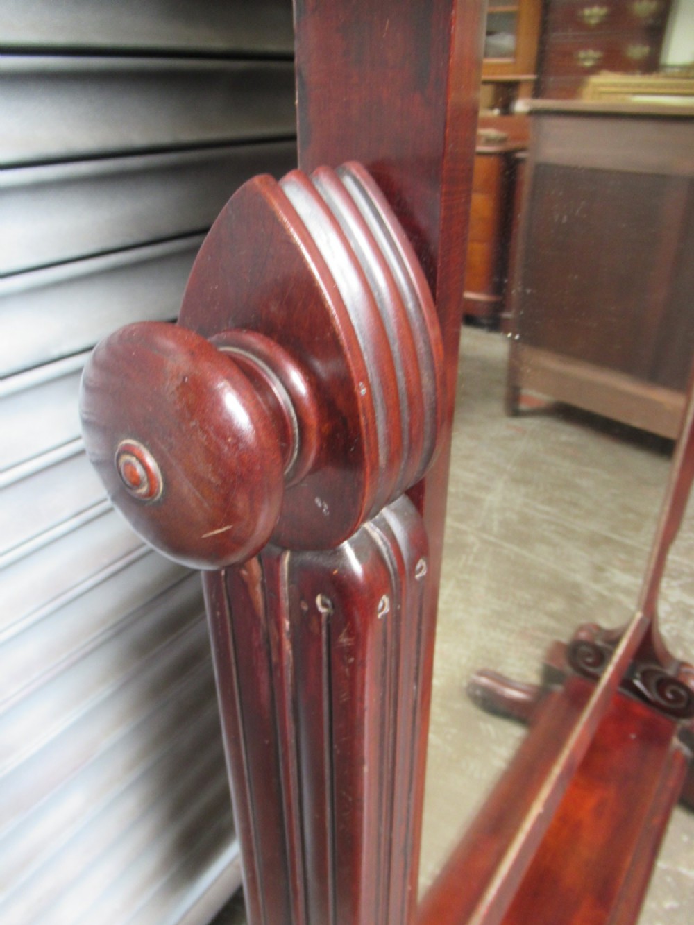 A 19th-century full-length mahogany cheval mirror featuring turned side adjustment handles, curved scroll legs, and a rectangular tilting glass frame. View V