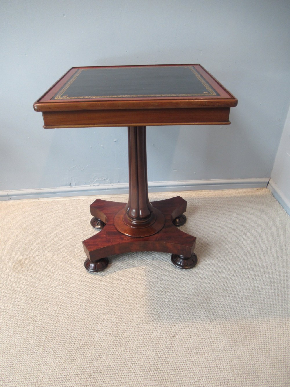 A 19th-century square mahogany side table featuring a dark leather top with gilt tooling, supported by a central turned pedestal and a quadform base. View II