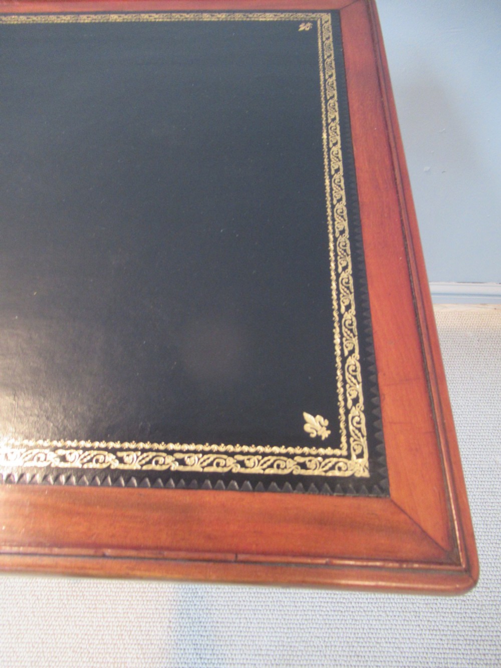 A 19th-century square mahogany side table featuring a dark leather top with gilt tooling, supported by a central turned pedestal and a quadform base. View IV
